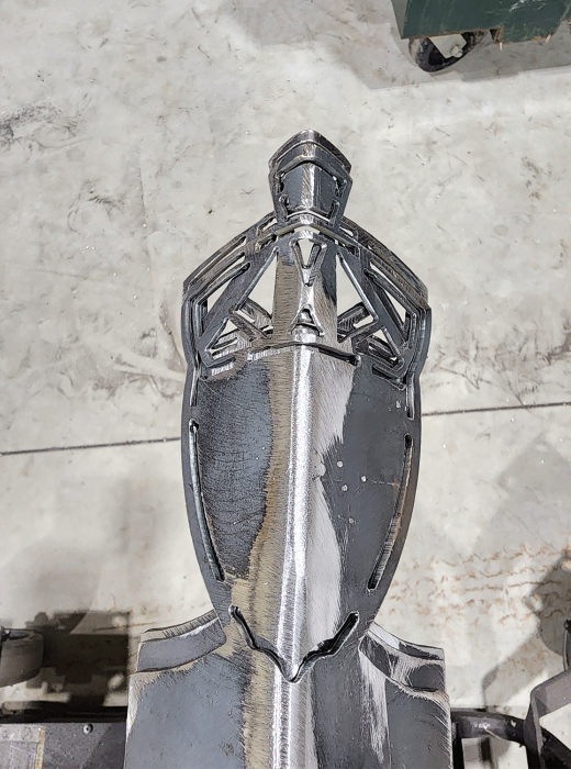 Welded and ground steel component featuring an intricate knight-themed decorative motif.